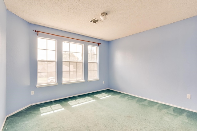 empty room with carpet flooring and a textured ceiling