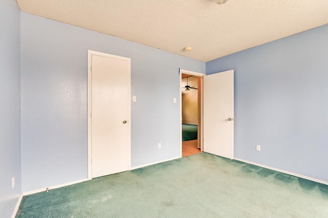 spare room featuring a textured ceiling, carpet flooring, and ceiling fan