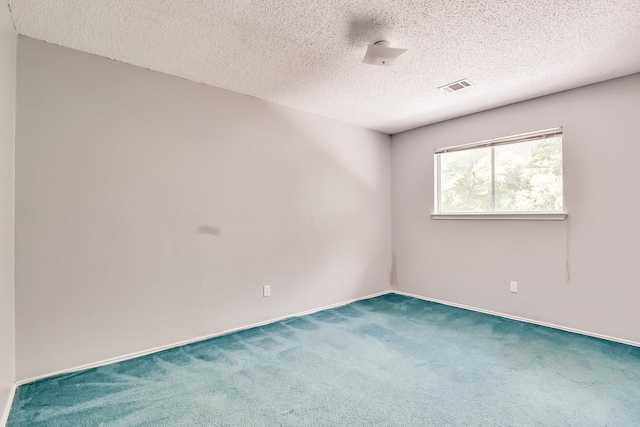 spare room featuring a textured ceiling and carpet