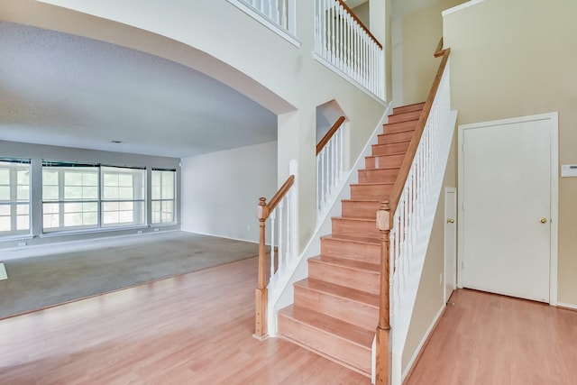 stairs featuring a textured ceiling and carpet