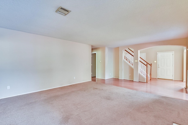 carpeted empty room with a textured ceiling