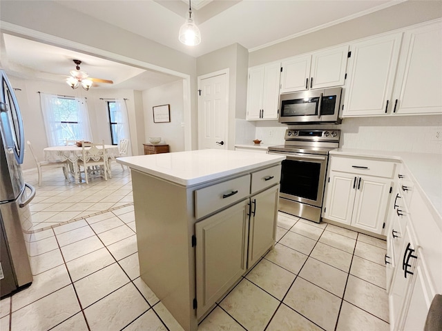 kitchen with a kitchen island, decorative light fixtures, appliances with stainless steel finishes, ceiling fan, and light tile patterned flooring