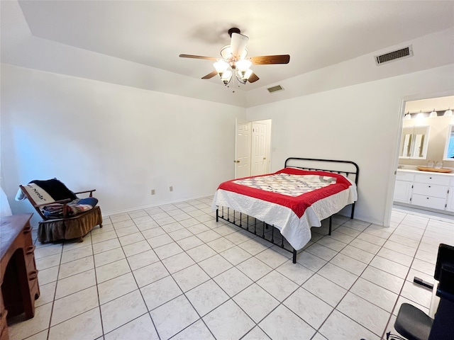 tiled bedroom with ceiling fan and ensuite bath