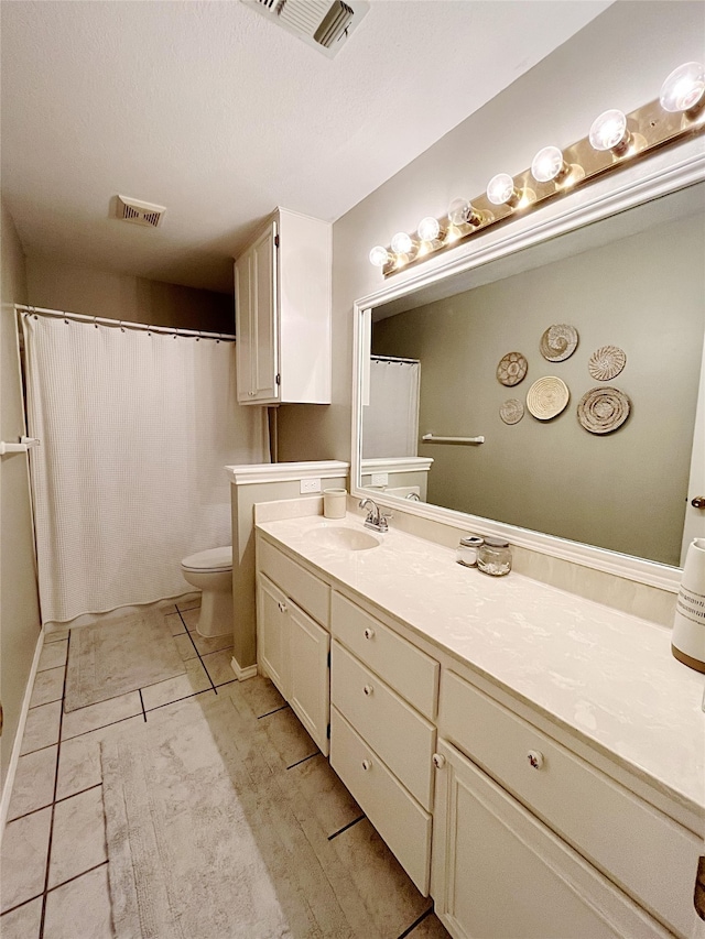 bathroom featuring curtained shower, tile patterned flooring, toilet, and vanity