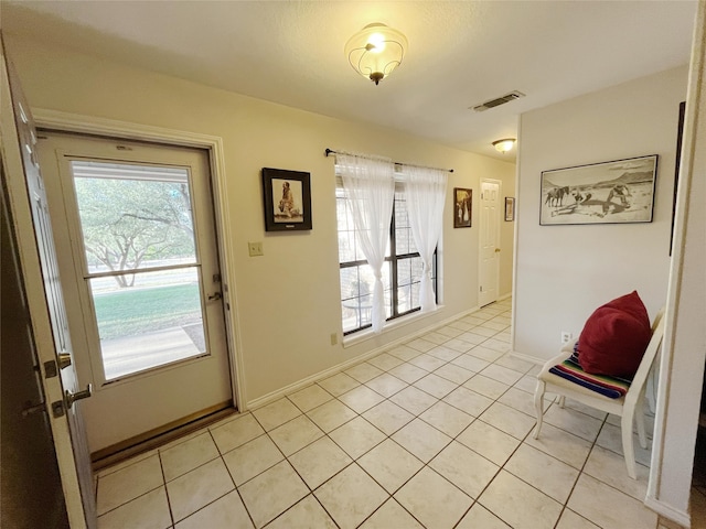 doorway to outside with a wealth of natural light and light tile patterned floors