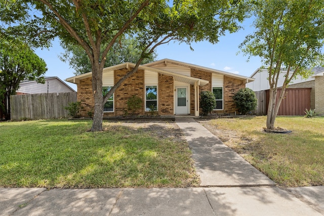 mid-century modern home featuring fence, a front lawn, and brick siding