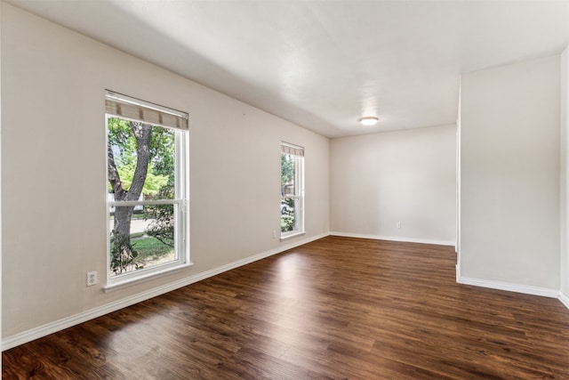 unfurnished room with plenty of natural light and dark hardwood / wood-style floors