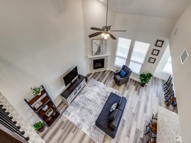 living room featuring ceiling fan, a wealth of natural light, hardwood / wood-style floors, and high vaulted ceiling