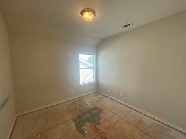 unfurnished room featuring vaulted ceiling