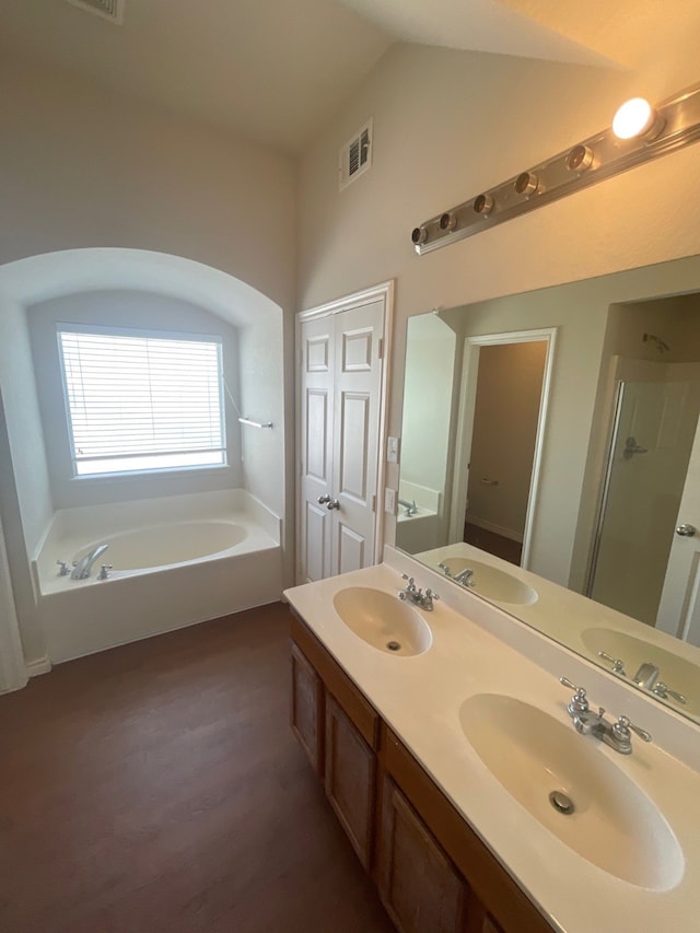 bathroom featuring lofted ceiling, vanity, separate shower and tub, and hardwood / wood-style flooring