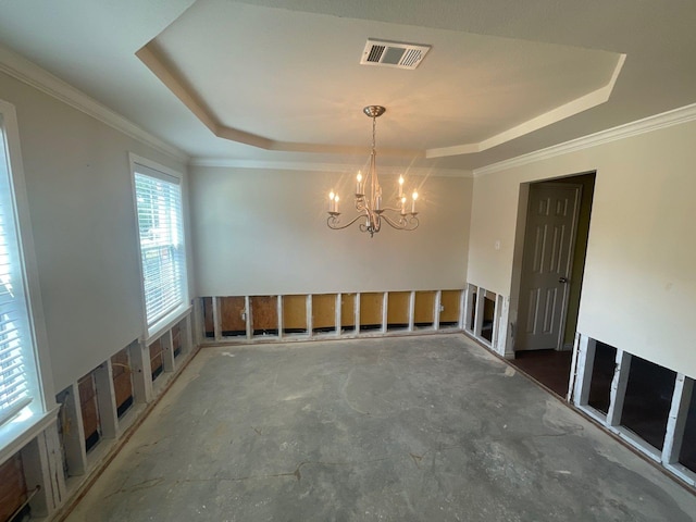 unfurnished dining area with crown molding, a tray ceiling, visible vents, and a notable chandelier