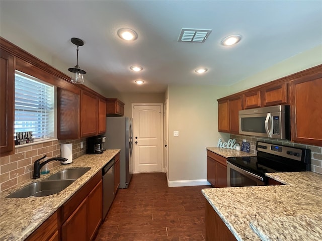 kitchen featuring pendant lighting, stainless steel appliances, sink, decorative backsplash, and dark wood-type flooring