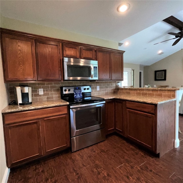 kitchen with lofted ceiling, ceiling fan, stainless steel appliances, and kitchen peninsula