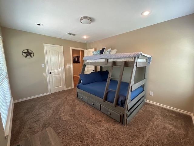 bedroom with dark colored carpet and a closet