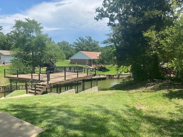 view of home's community featuring a lawn and a water view