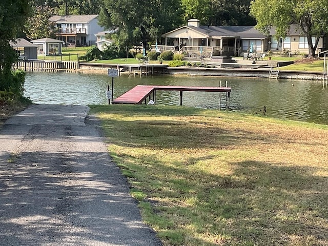 view of dock featuring a water view and a lawn