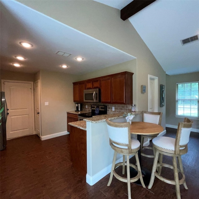 kitchen with dark hardwood / wood-style floors, light stone countertops, appliances with stainless steel finishes, decorative backsplash, and vaulted ceiling with beams