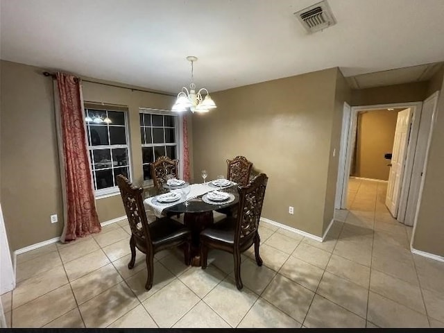 dining room with light tile patterned floors and a chandelier