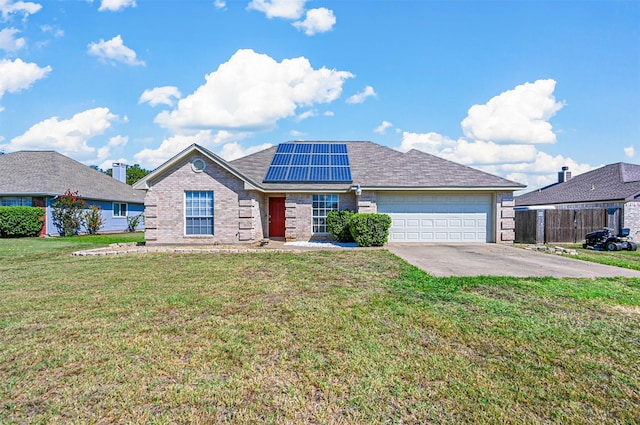 view of front of home featuring a front lawn, solar panels, and a garage