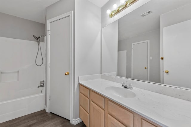 bathroom with shower / bathtub combination, vanity, and hardwood / wood-style flooring