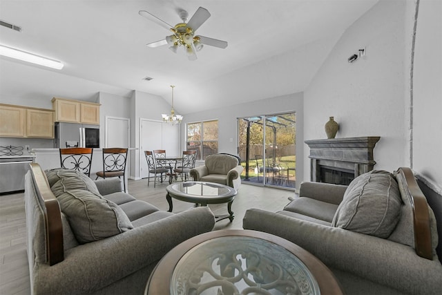 living room featuring ceiling fan with notable chandelier, vaulted ceiling, and light hardwood / wood-style flooring