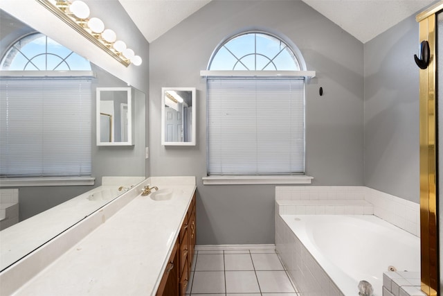 bathroom with a textured ceiling, lofted ceiling, tiled bath, tile patterned floors, and vanity