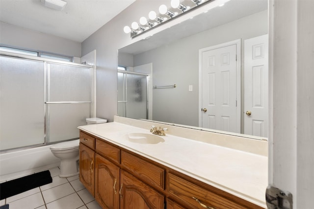 full bathroom featuring toilet, a textured ceiling, tile patterned flooring, shower / bath combination with glass door, and vanity