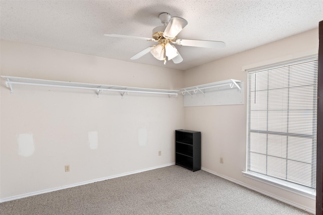 walk in closet with ceiling fan and carpet floors