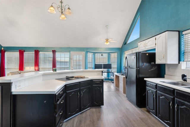 kitchen with vaulted ceiling, black appliances, decorative backsplash, ceiling fan with notable chandelier, and white cabinets