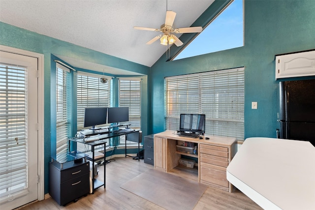 office area with ceiling fan, light wood-type flooring, lofted ceiling, and a textured ceiling