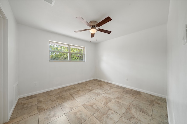 empty room with ceiling fan and light tile patterned floors