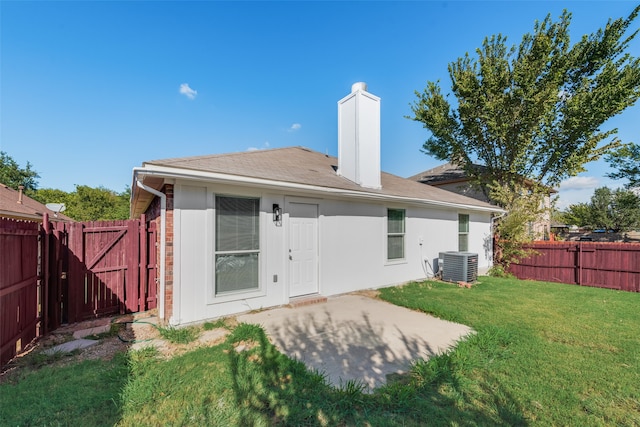 rear view of property with central AC unit, a yard, and a patio