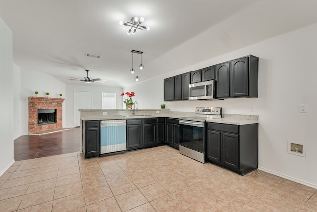 kitchen with hanging light fixtures, appliances with stainless steel finishes, sink, kitchen peninsula, and ceiling fan