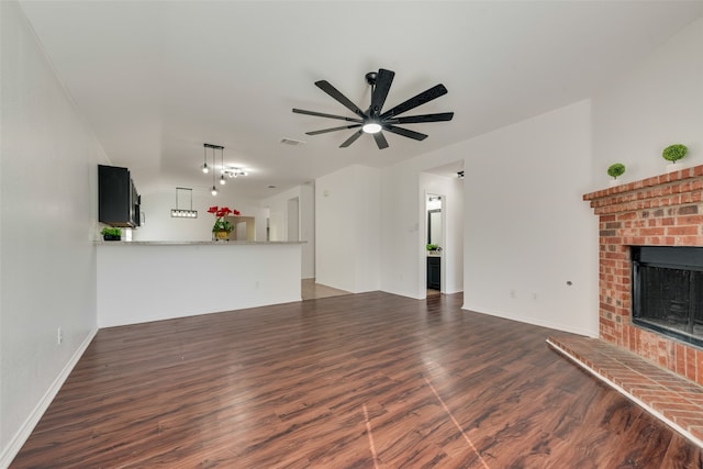 unfurnished living room with a fireplace, ceiling fan, and dark hardwood / wood-style floors