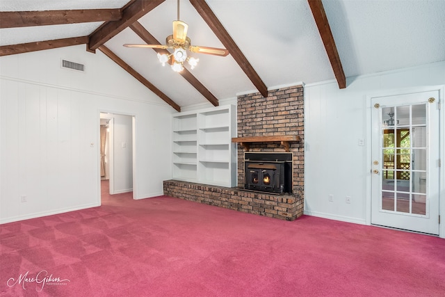 unfurnished living room featuring beamed ceiling, a brick fireplace, ceiling fan, and carpet floors