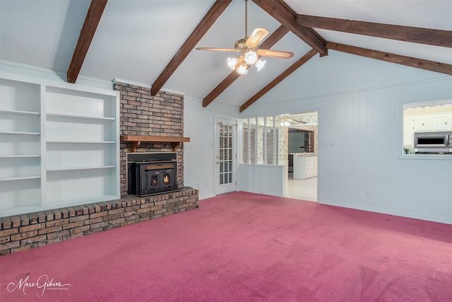 unfurnished living room with built in shelves, a brick fireplace, ceiling fan, carpet, and lofted ceiling with beams