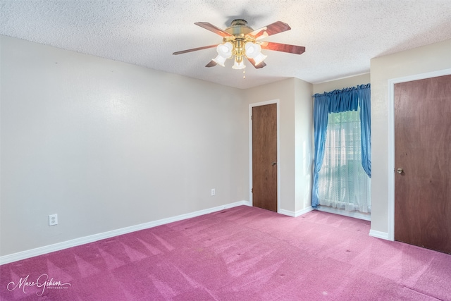 empty room with a textured ceiling, light colored carpet, and ceiling fan