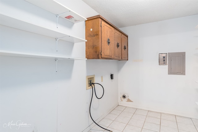 washroom with cabinets, a textured ceiling, electric panel, washer hookup, and light tile patterned flooring