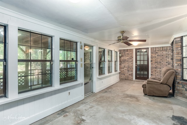 unfurnished sunroom with ceiling fan