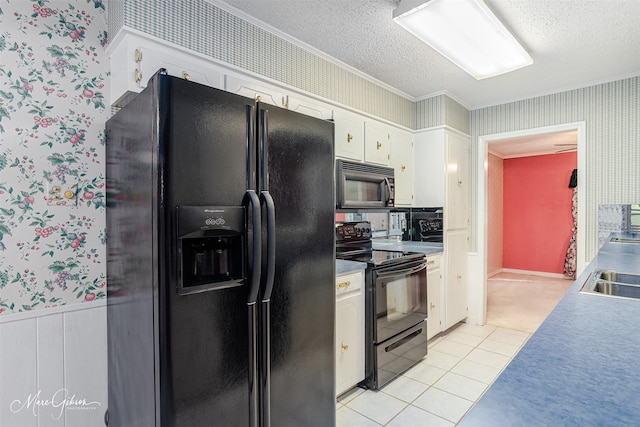 kitchen with a textured ceiling, black appliances, light tile patterned floors, sink, and white cabinetry