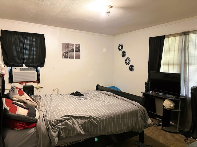 bedroom featuring cooling unit, carpet floors, a textured ceiling, and ornamental molding