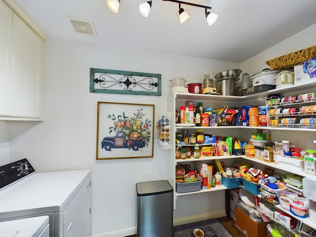 washroom featuring cabinets and separate washer and dryer