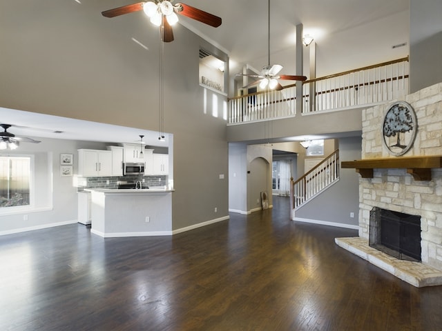 kitchen with pendant lighting, appliances with stainless steel finishes, dark wood-type flooring, sink, and kitchen peninsula