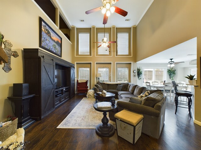 foyer featuring a notable chandelier, a towering ceiling, crown molding, and dark hardwood / wood-style flooring