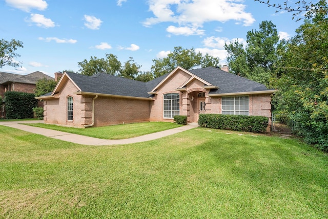 single story home with fence, roof with shingles, a chimney, a front lawn, and brick siding