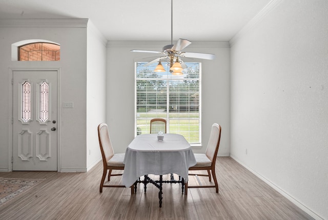 dining area with light wood finished floors, baseboards, a ceiling fan, and ornamental molding