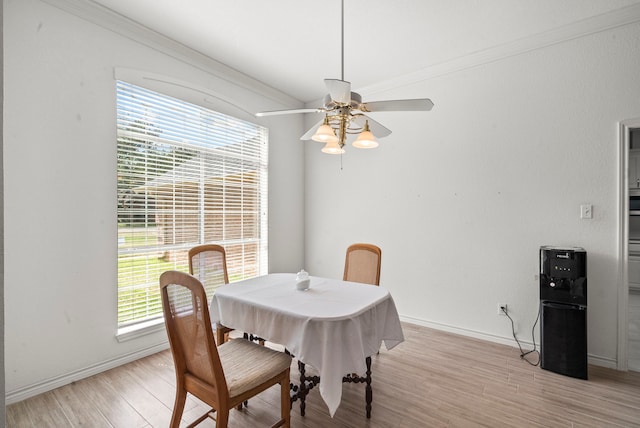 dining area with crown molding, light wood-style flooring, a ceiling fan, and baseboards