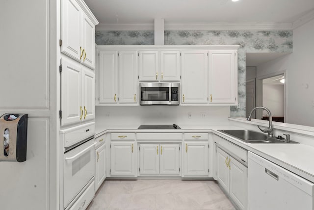 kitchen featuring white appliances, white cabinetry, light countertops, and a sink