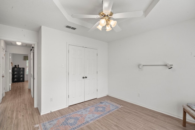 bedroom featuring visible vents, baseboards, light wood-style floors, and a closet