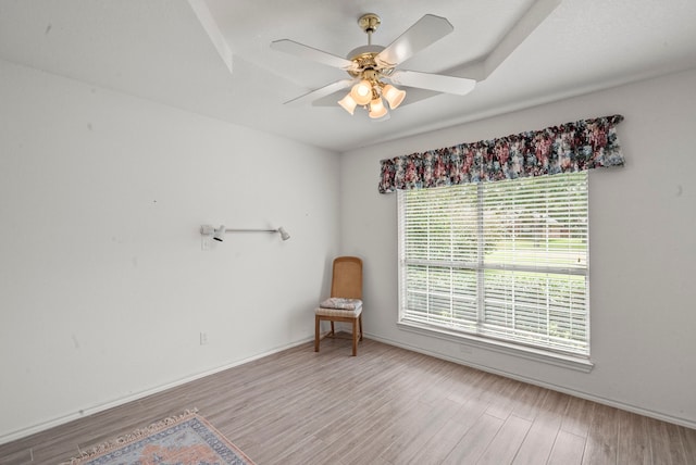 spare room with a ceiling fan, wood finished floors, and baseboards
